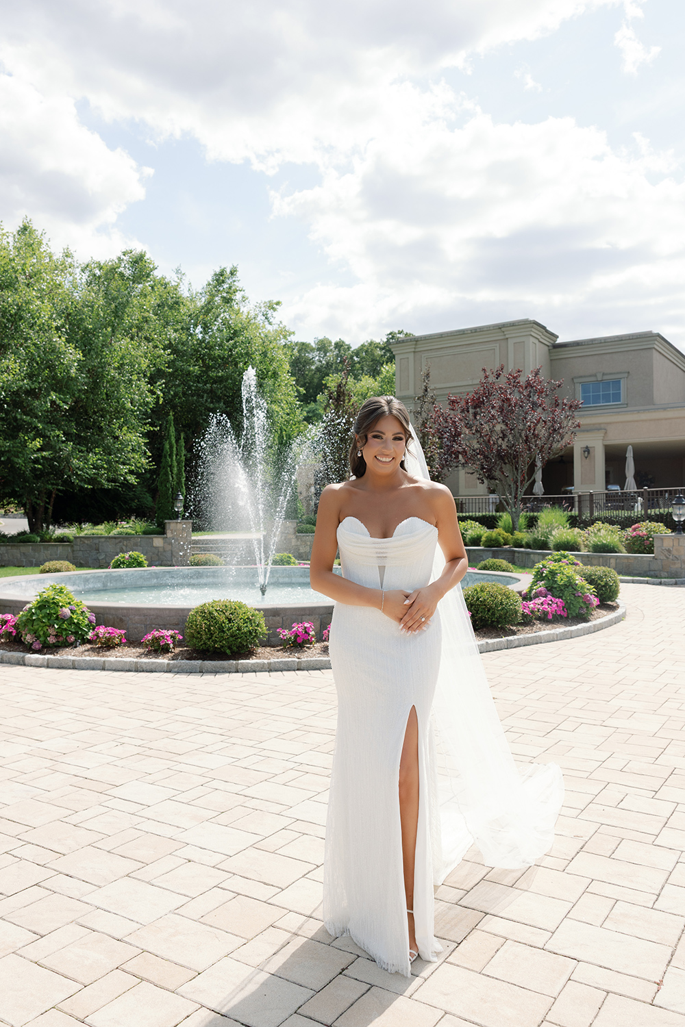 bride posing outside of aria in front of a water display