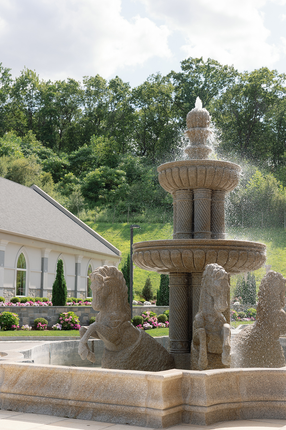 a water fountain with greenery in the background