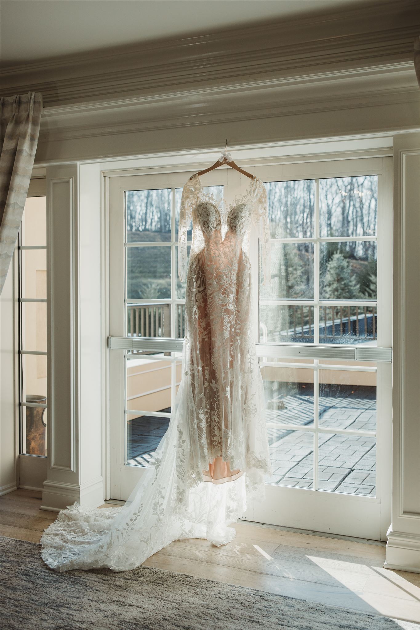 wedding dress hanging in front of a window