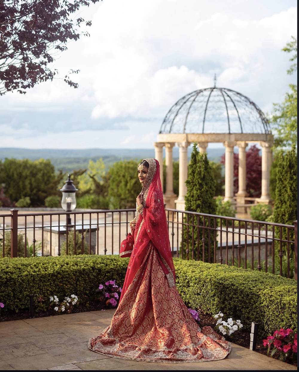 a bride posing outside with the aria gazebo behind her