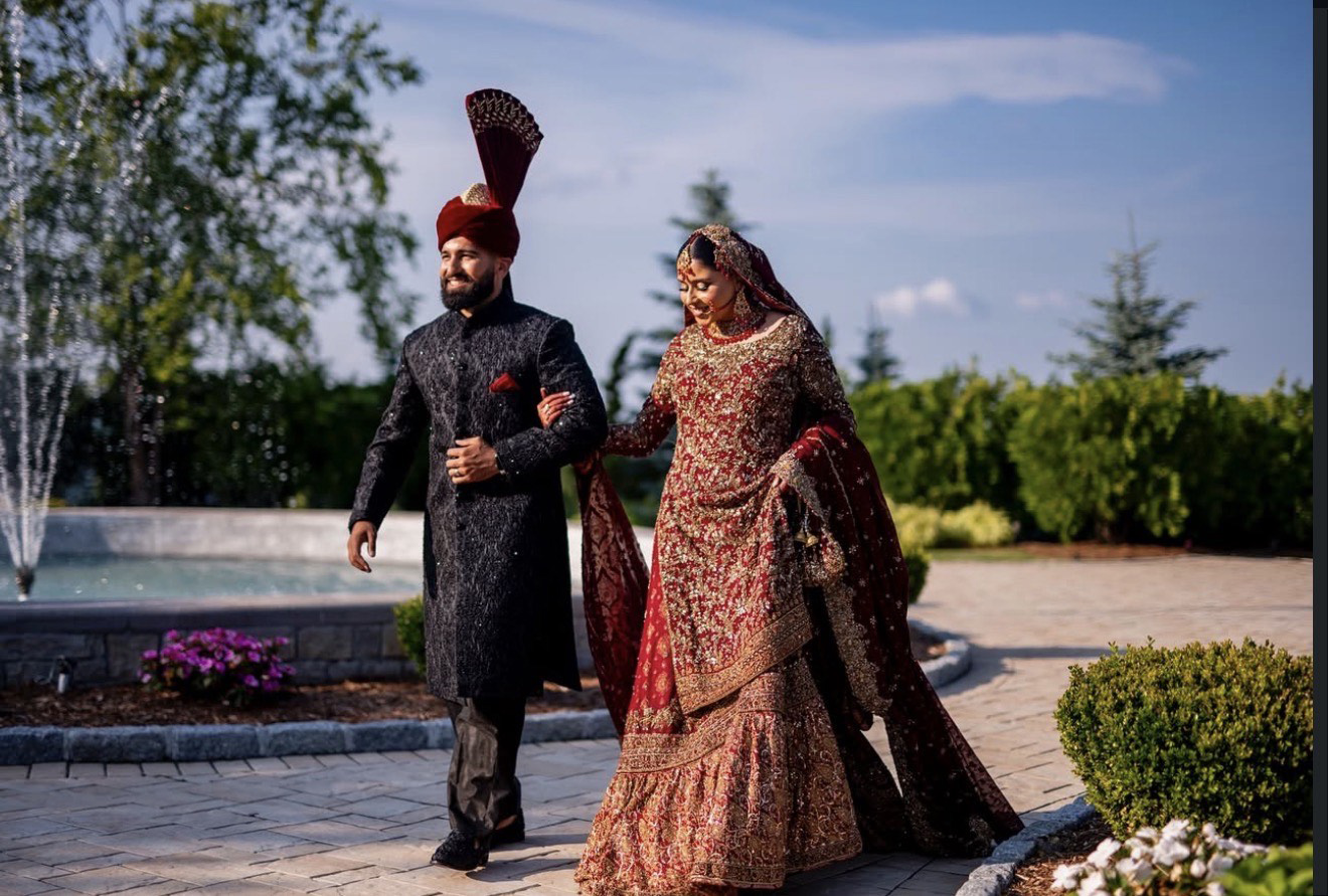 a bride and a groom walking outside on the aria grounds