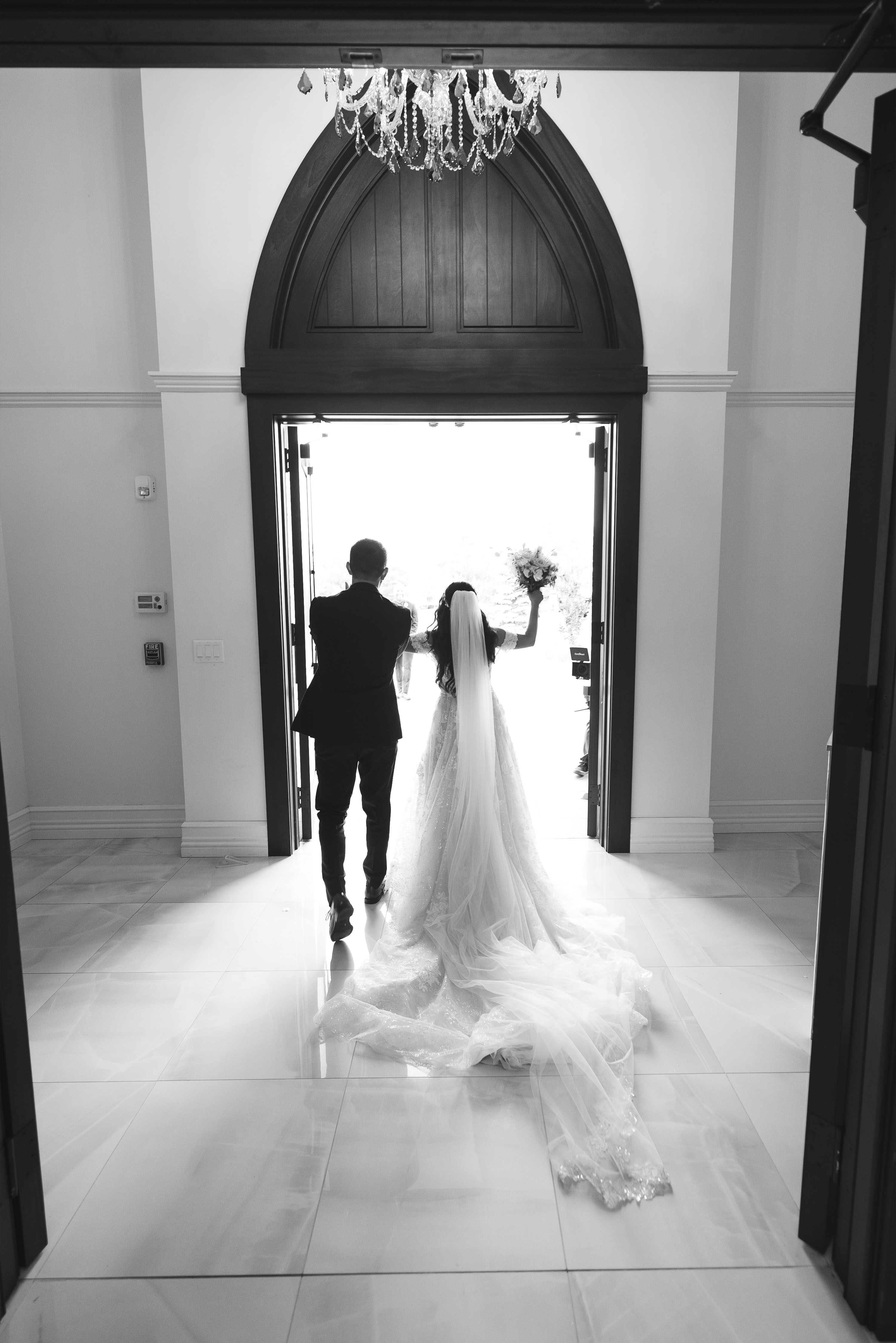 a bride and groom walking out of the chapel after getting married