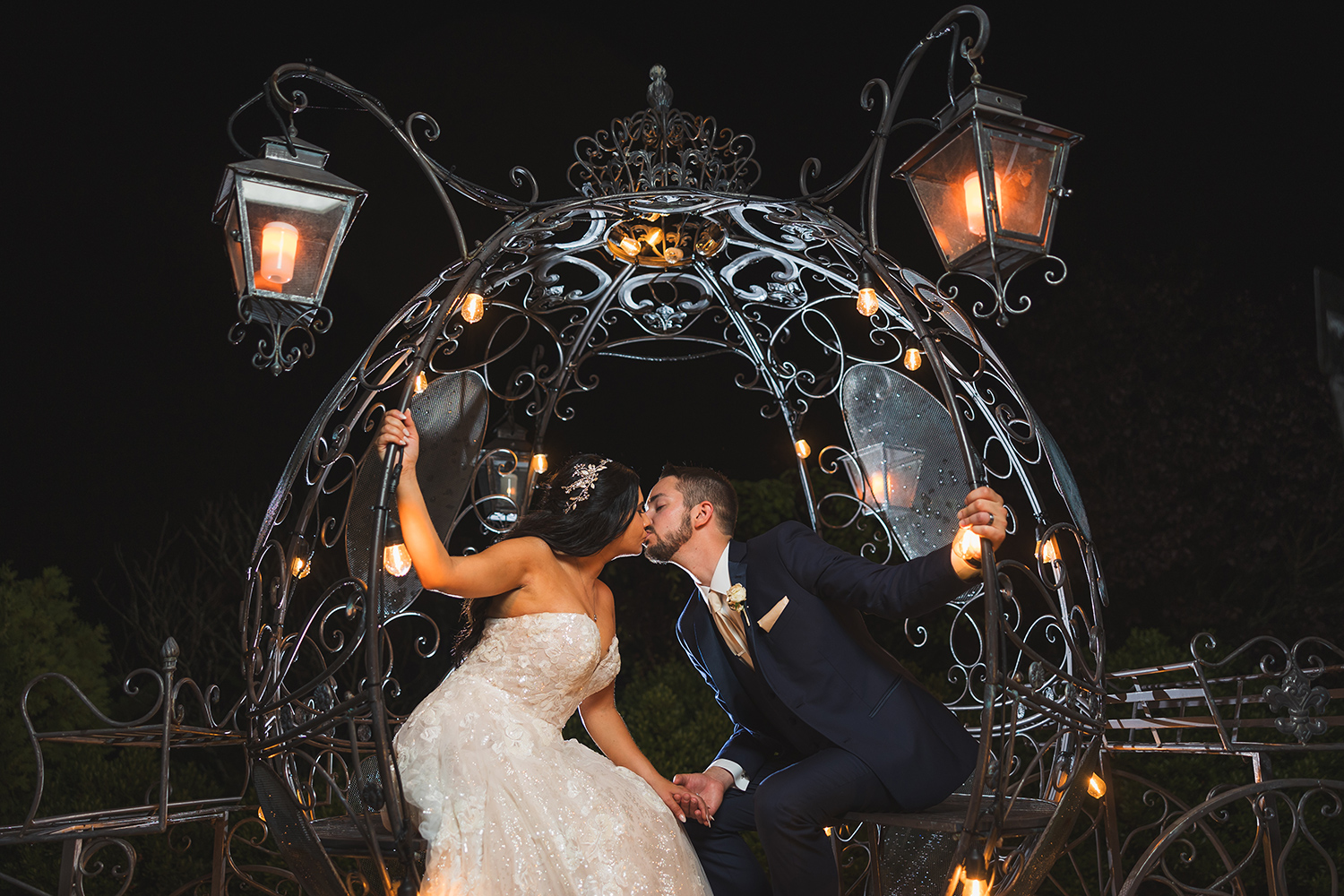 a bride and groom share a kiss outside in a metal wire carriage 