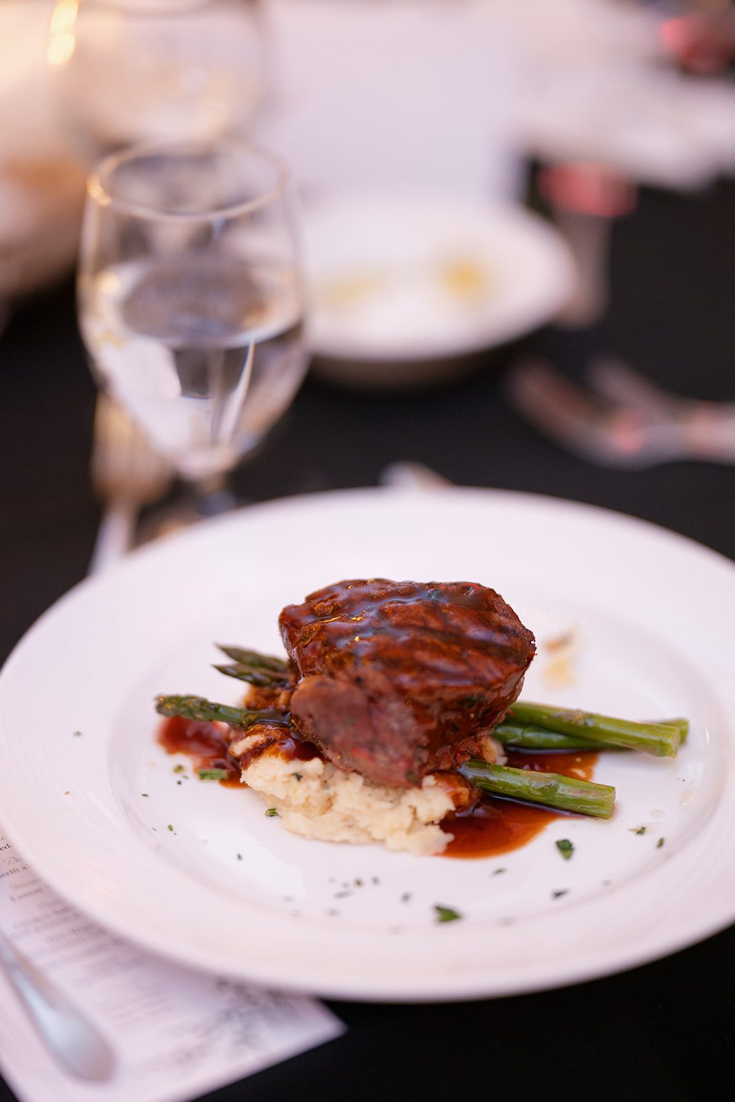 steak and asparagus on top of mashed potatoes