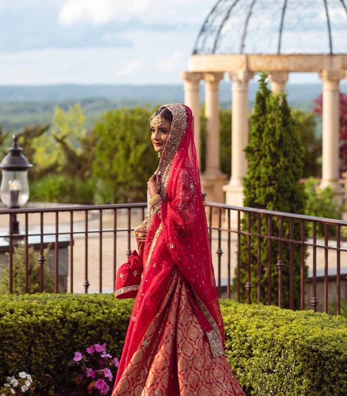 a bride posing in traditional wedding attire outside with the gazebo in the background