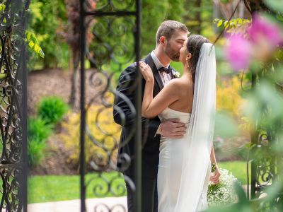Bride and groom kissing each other outside