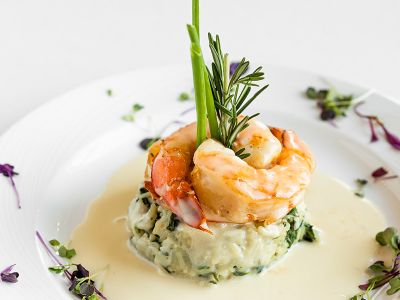 Elegantly plated course of shrimp and rice.