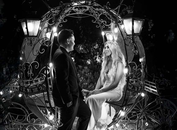 a bride and groom in a lantern lit metal carriage