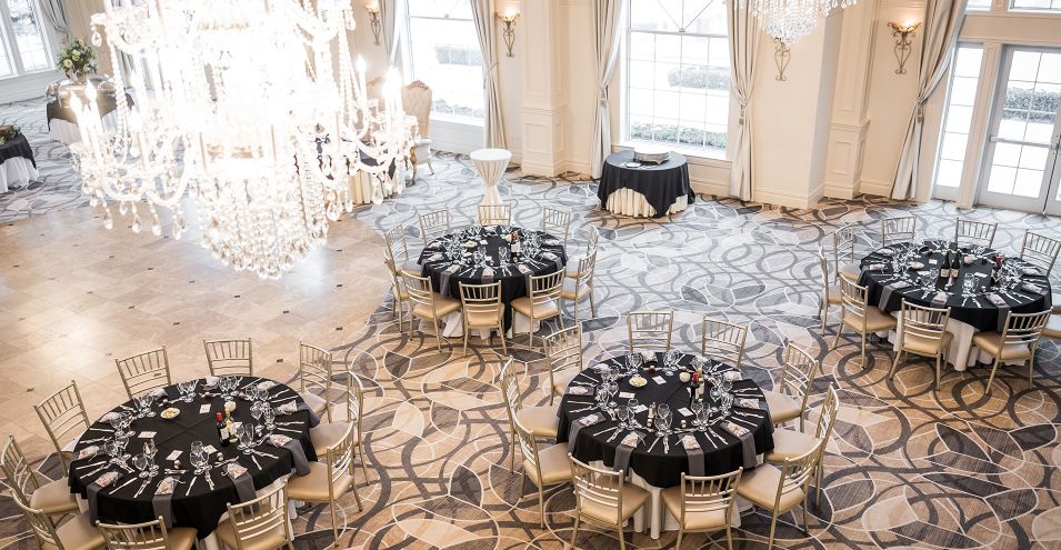 Elegant ballroom with round tables set for a wedding.